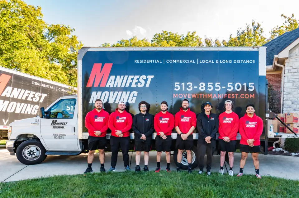 Manifest Moving crew standing in front of a branded moving truck