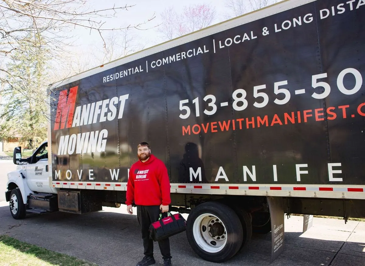Manifest Moving mover standing beside a branded moving truck