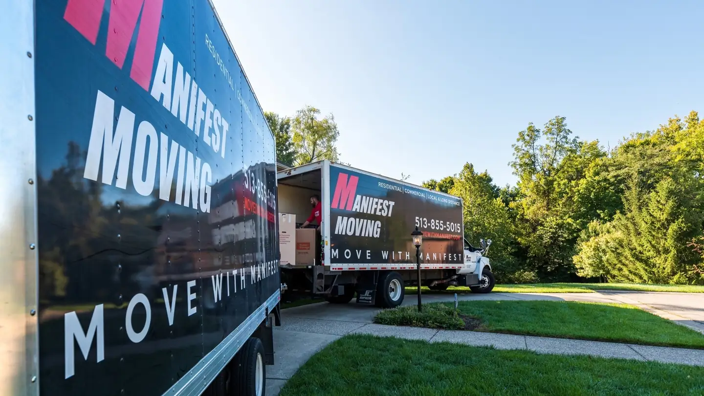 Manifest Moving trucks being loaded outside a home